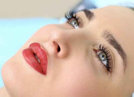 Healthy Spa: Young Beautiful Woman Having Permanent Make-up Tattoo on her Lips. Close-up
